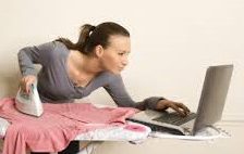 A woman is using her laptop on the bed