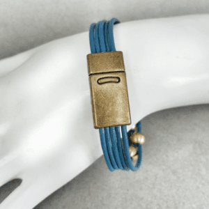 A woman 's arm with a blue bracelet on it.