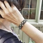A person wearing a bracelet with spikes on it