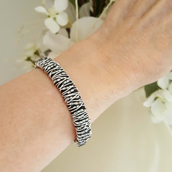 A woman wearing a bracelet with zebra print.