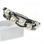 A black and white bracelet with pearls on it