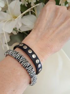 A woman wearing two bracelets with silver rivets.
