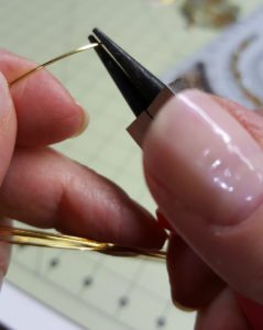 A person is using a needle to thread a wire.