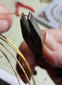 A person holding a pair of scissors and wire.