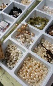 A white tray filled with lots of different pearls.