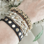 A woman 's arm with bracelets on her wrist.