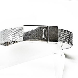 A silver bracelet is shown on top of a white surface.