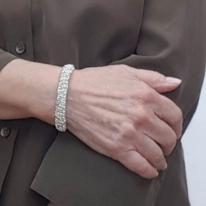 A woman wearing a bracelet with diamonds on it.