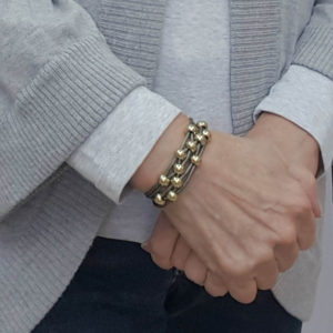 Gray Leather Bracelet with gold beads on wrist.