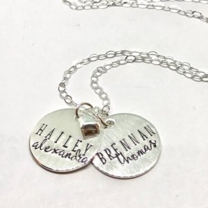 A silver necklace with two names on it.
