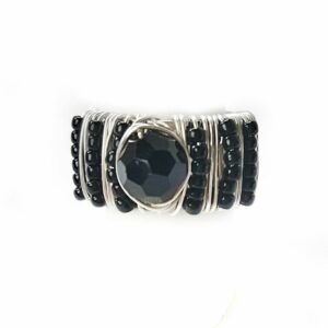 Adjustable silver ring hand beaded with black seed beads and faceted center stone.