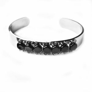 A silver bracelet with black stones on it.