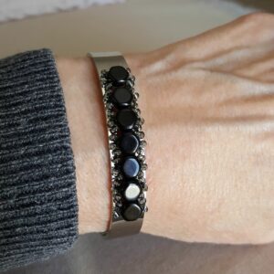Adjustable silver cuff bracelet with jet black Czech beads on wrist.