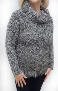 Woman wearing an old diy clothing sweater after it has decorative fabric added to the bottom.