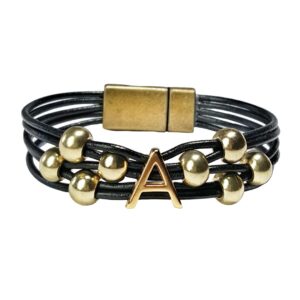 A leather bracelet with gold beads and an initial.