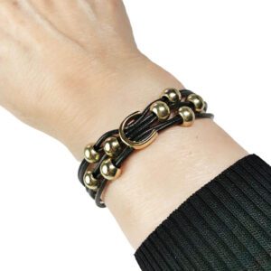 A person wearing a black and gold bracelet