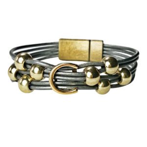 A gray leather bracelet with gold beads and a magnetic clasp.