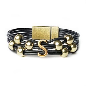 A black leather bracelet with gold beads and an initial.