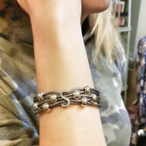 A woman wearing a bracelet with two different chains.