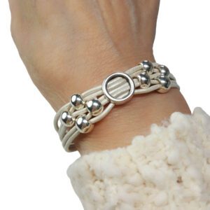 A person wearing a bracelet with silver beads