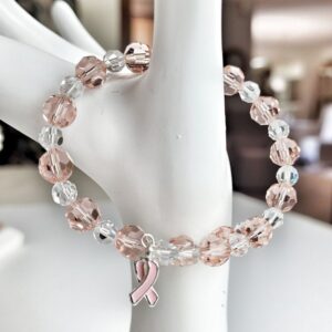Breast Cancer Awareness Bracelet on hand display showing silver trimmed enamel pink ribbon charm.