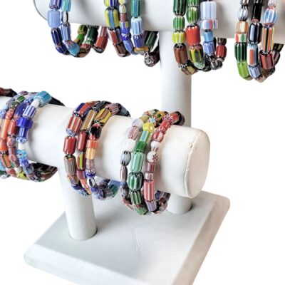 A white display stand with many different colored bracelets.