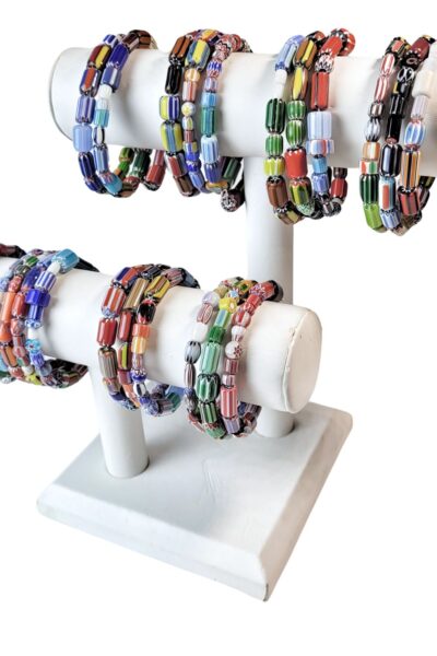 A white display stand with many different colored bracelets.